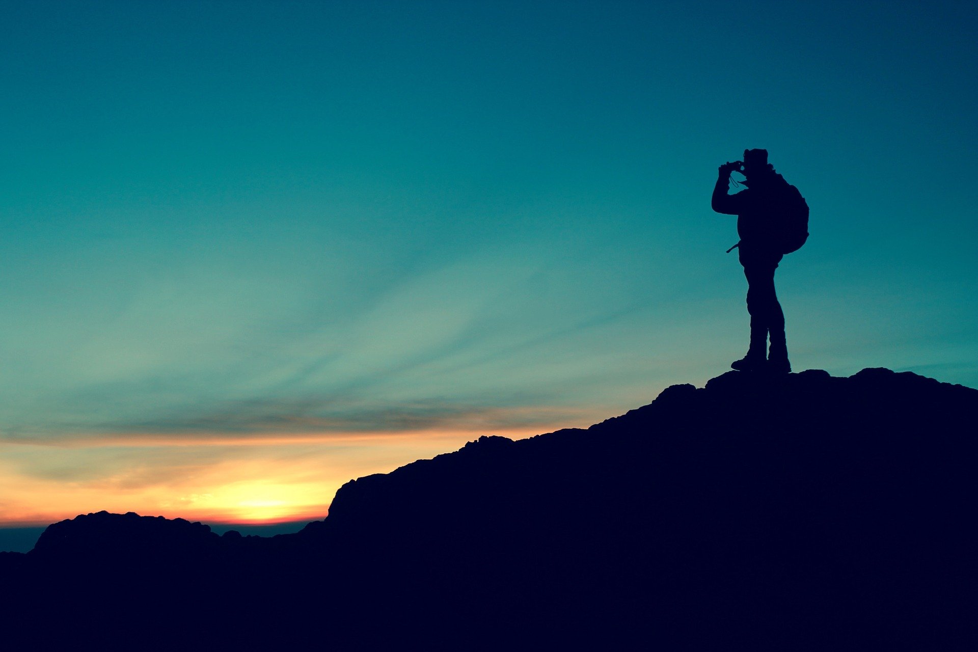 Hiker overlooking mountain at sunset